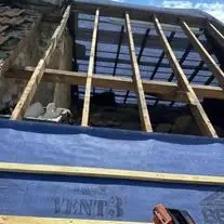 New timber battens fixed over blue breathable membrane on a pitched roof that has been stripped