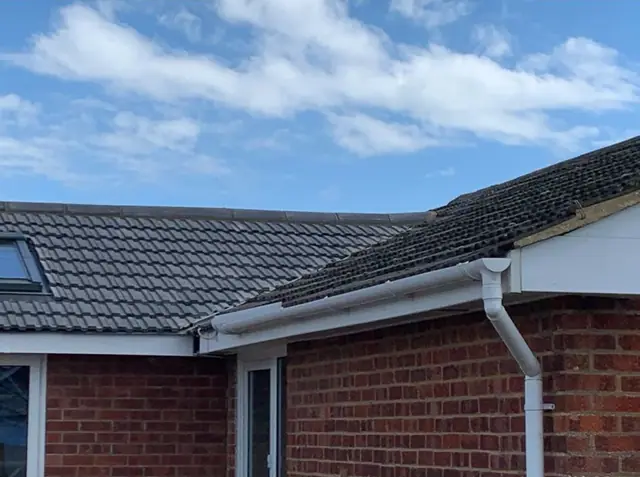 White uPVC fascias, soffits and guttering along the eaves of a brick bungalow with a tiled roof